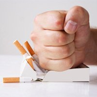 Fist smashing pack of cigarettes on white table
