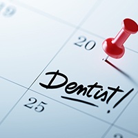 Dentist appointment marked on calendar with red thumbtack