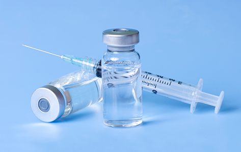 Two vials of clear liquid and a syringe