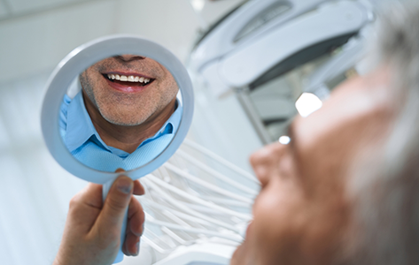 Patient looking at his smile in a mirror