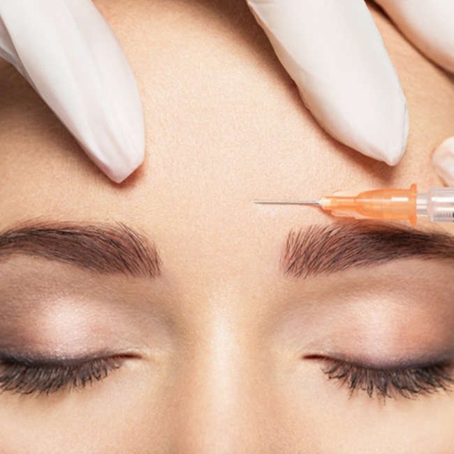 Woman relaxing while receiving BOTOX® injection in forehead