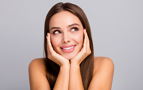 Smiling woman framing her face with her hands