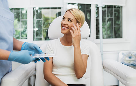 Smiling woman talking to her oral surgeon