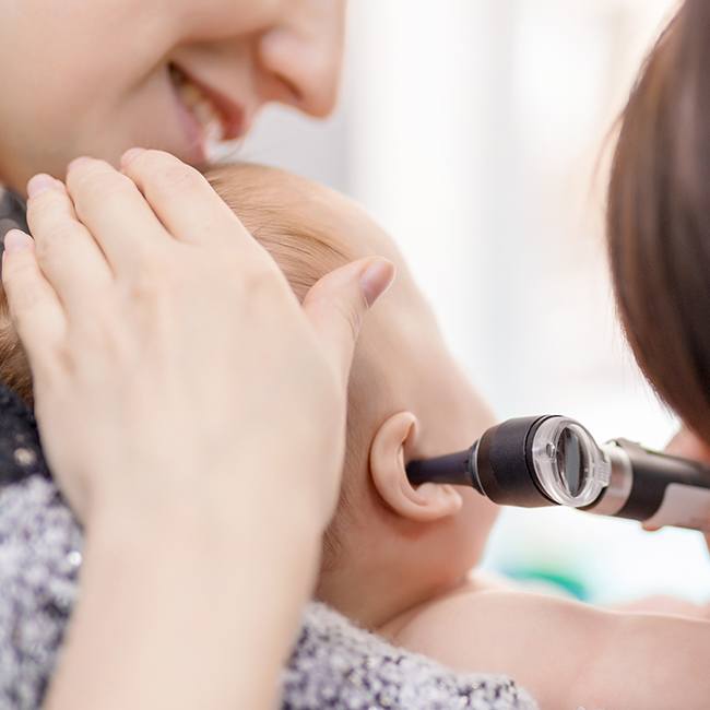 Doctor checking baby's ears