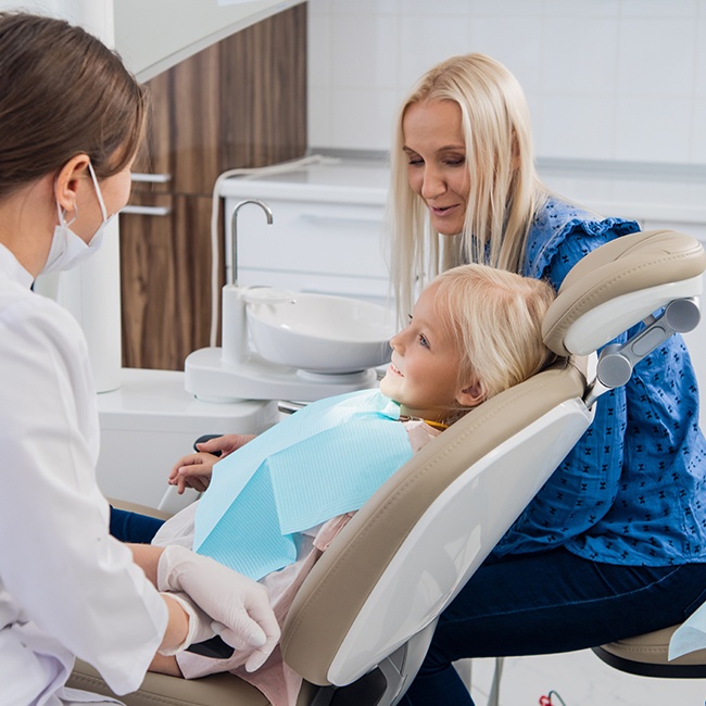 Child and mother talking to oral surgeon about cleft lip and palate treatment