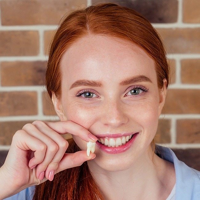 Woman holding an extracted tooth