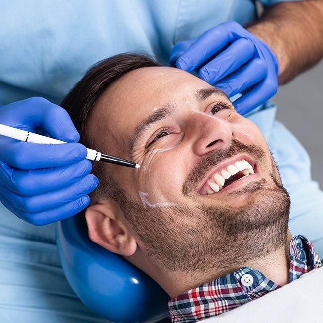 Smiling man during facial implant treatment