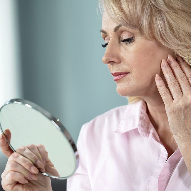 Woman looking at face after Restylane treatment