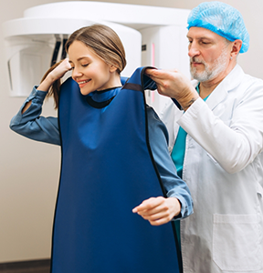 Doctor placing a robe over a patient before a CT scan