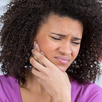 Woman with toothache holding jaw