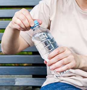 Person opening a water bottle with their hands