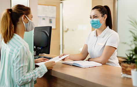 Woman checking at the front desk of a dental office