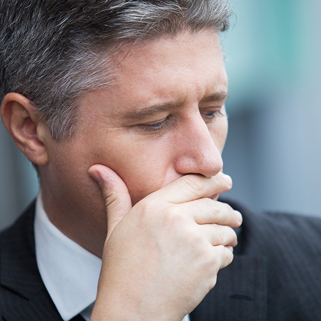 Man with broken jaw covering his mouth