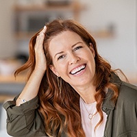 Smiling middle-aged woman with dental implants in Houston