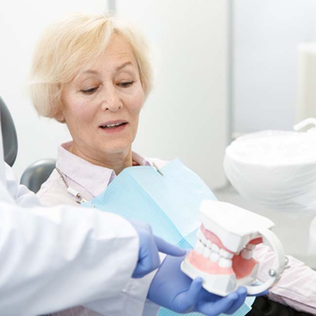Dentist and patient discussing candidacy for implant dentures