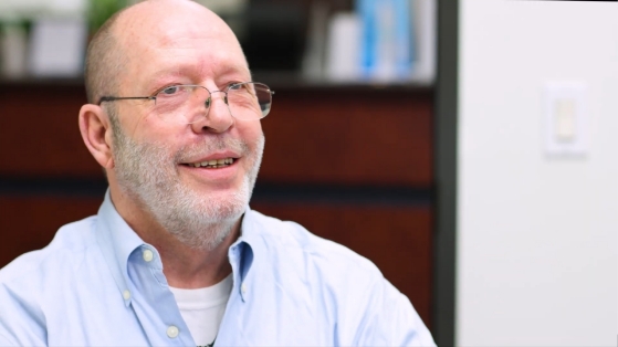 Older man with glasses giving testimonial in oral surgery office in Houston
