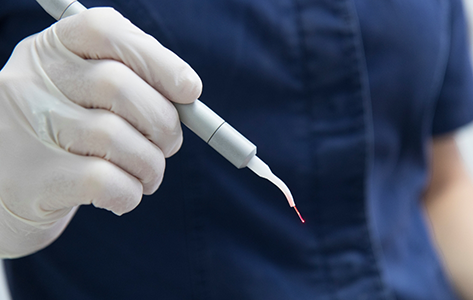 Dental professional holding a laser pen