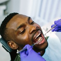 Man with dental implants attending routine dental exam