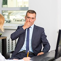 Businessman with oral cancer in Houston covering his mouth