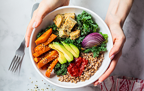 Person holding a bowl of salad