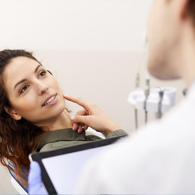 Woman talking to orthodontist after orthognathic surgery