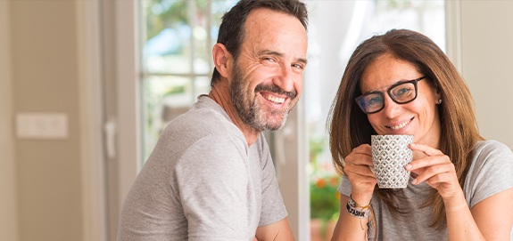 Man and woman smiling after oral and maxillofacial pathology