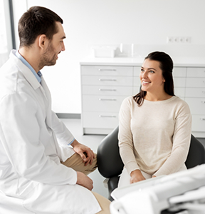 Woman listening to her oral surgeon in the treatment room