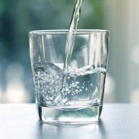 Person pouring a glass of water