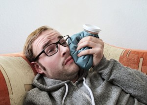 man resting with ice pack after oral surgery from the oral surgeon houston prefers