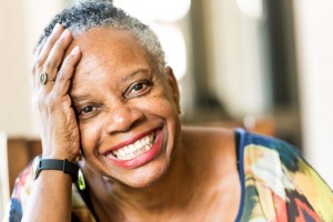 woman with a beautiful smile thanks to implant retained dentures in houston