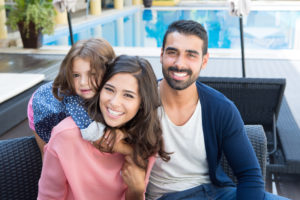 family relaxing by the pool