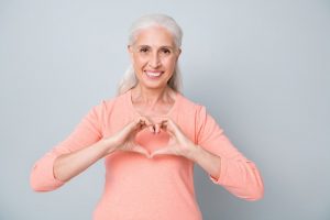 older woman making heart hands