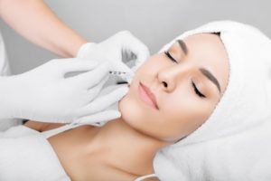 Relaxed woman receiving dermal filler from oral surgeon in Houston