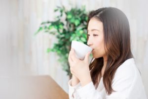 Woman enjoying soup while recovering from wisdom tooth removal