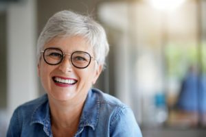 Senior woman smiling after making transition from dentures