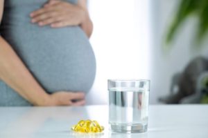 Pregnant woman preparing to take prenatal vitamins