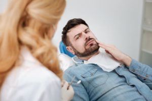 Frowning dental patient, concerned about root canal retreatment