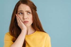 Woman in yellow blouse, suffering from a toothache