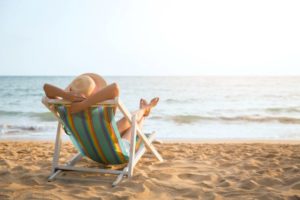 Woman relaxing on beach after wisdom tooth surgery