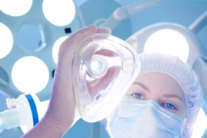 Surgical team member preparing to administer general anesthesia