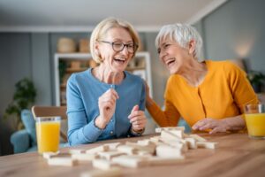 Two senior women laughing while playing a game